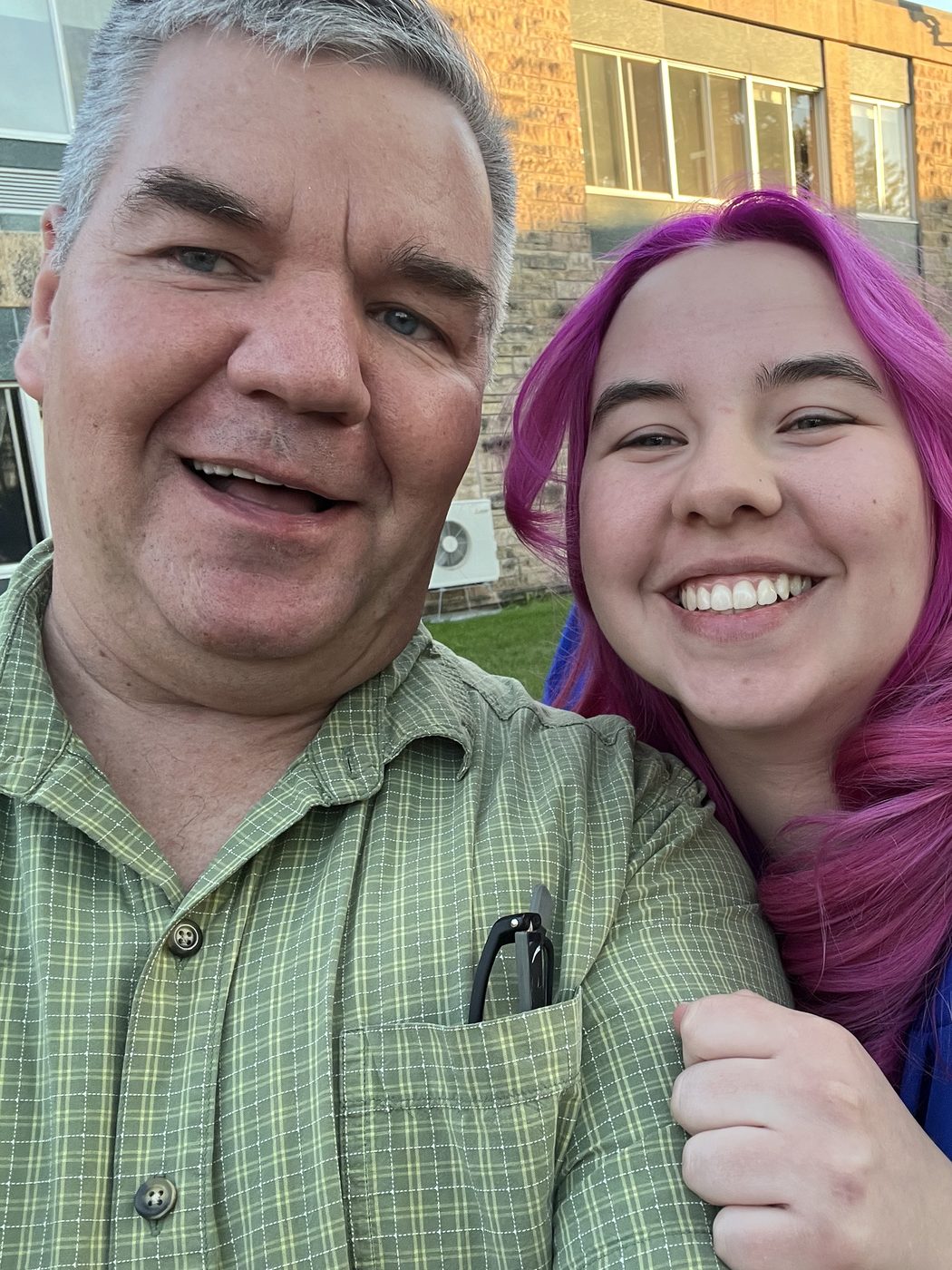 Toby Leonard taking a selfie with a smiling graduate in a blue cap and gown